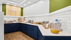 A modern kitchen with dark blue cabinets, white countertops, and a wooden floor.