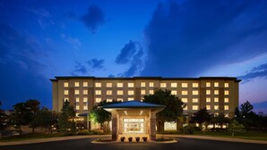 A large hotel with a central entrance, multiple floors, and a well-lit facade. - Hilton Garden Inn Denver South Park Meadows Area (Englewood)