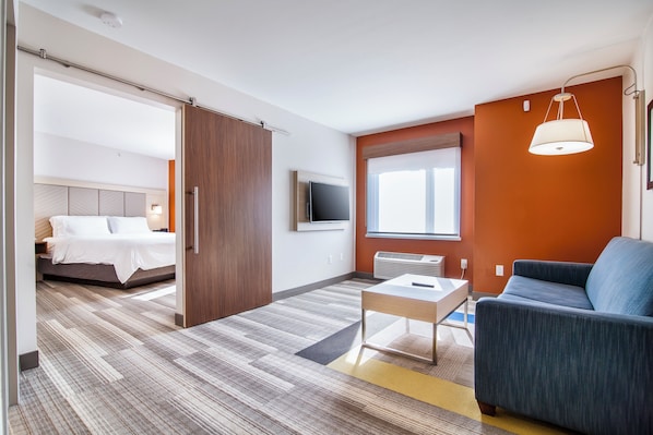 Une chambre d’hôtel avec un lit, un bureau, une chaise, une télévision et une fenêtre.