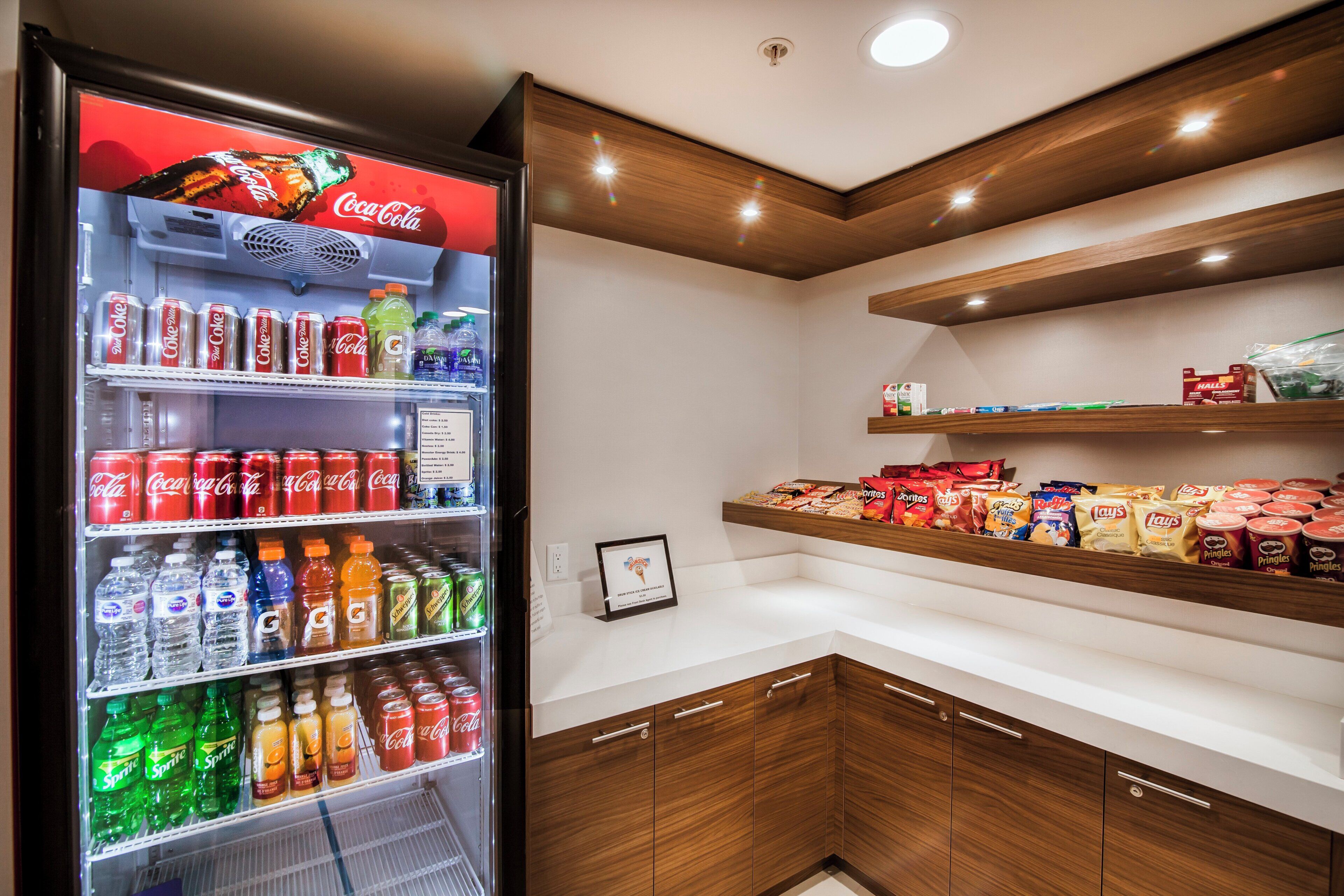 Máquina expendedora repleta de diversas bebidas y aperitivos, incluyendo Coca-Cola, Sprite y Doritos.