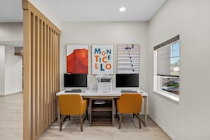 A modern office space with two desks, two chairs, and three monitors. - Holiday Inn Express Monticello by IHG (Monticello)