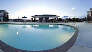 A swimming pool with a covered area, lounge chairs, and a clear sky. - Holiday Inn Express Monticello by IHG (Monticello)