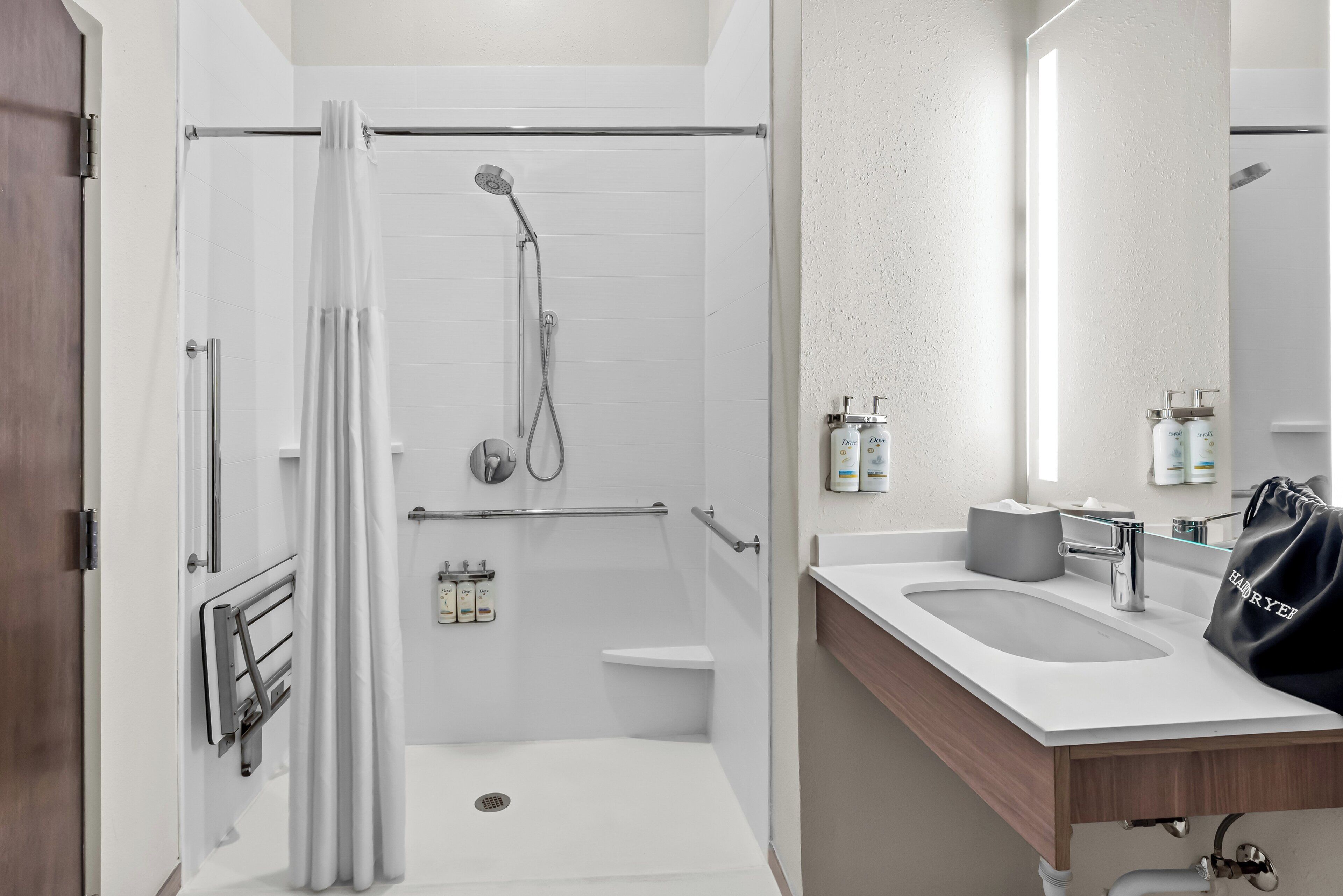 Een moderne badkamer met douche, toilet en wastafel.