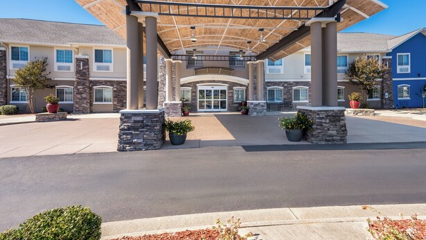 A covered entrance with a curved roof, stone pillars, and potted plants. - Holiday Inn Express Monticello by IHG (Monticello)
