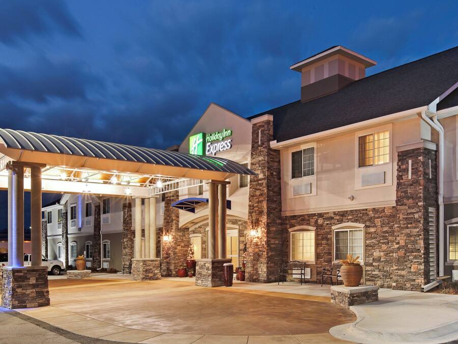 A Holiday Inn Express building with a covered outdoor area, stone facade, and a sign indicating the hotel name.