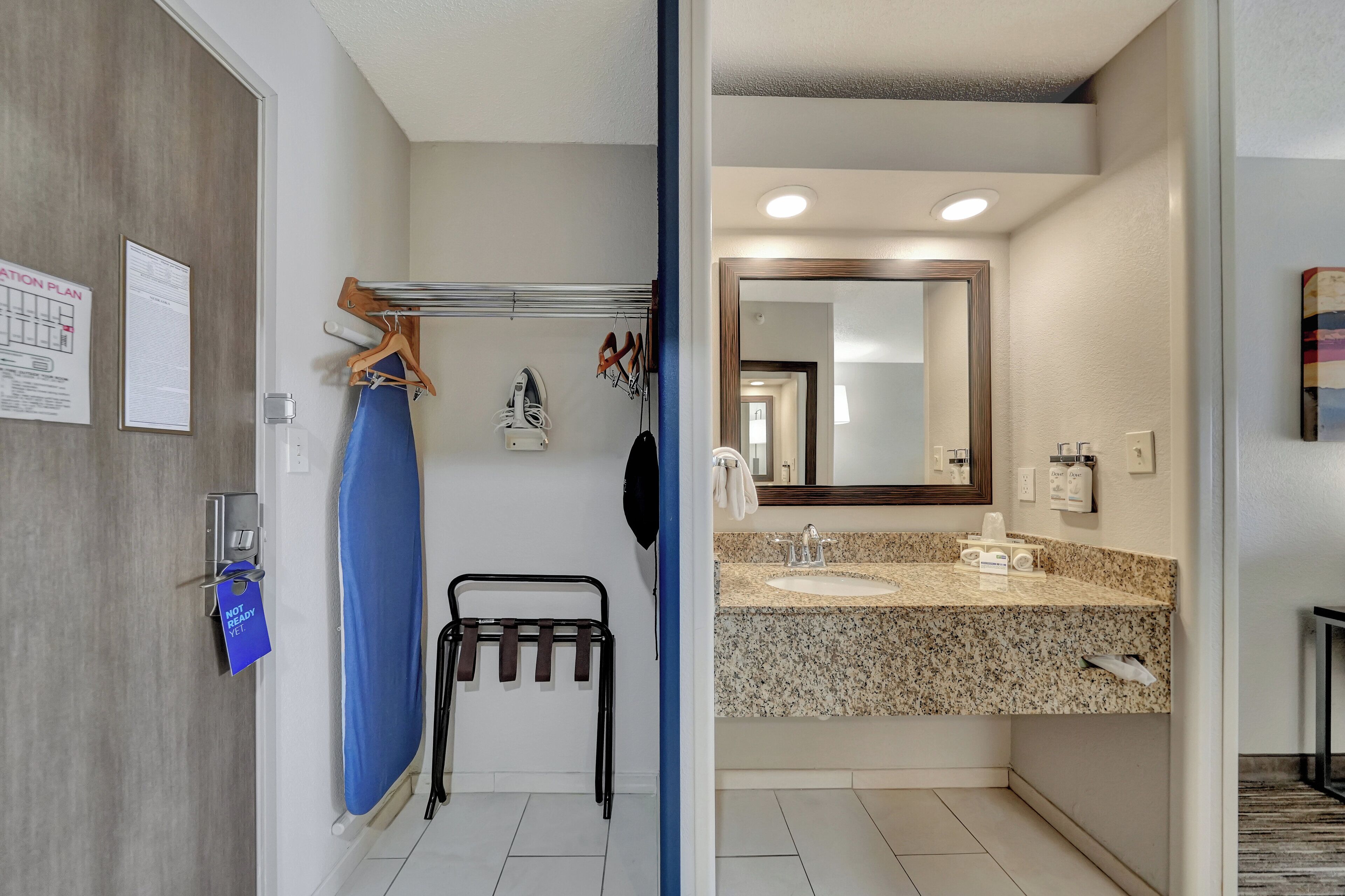 A bathroom with a granite countertop, a sink, a mirror, and a towel rack.