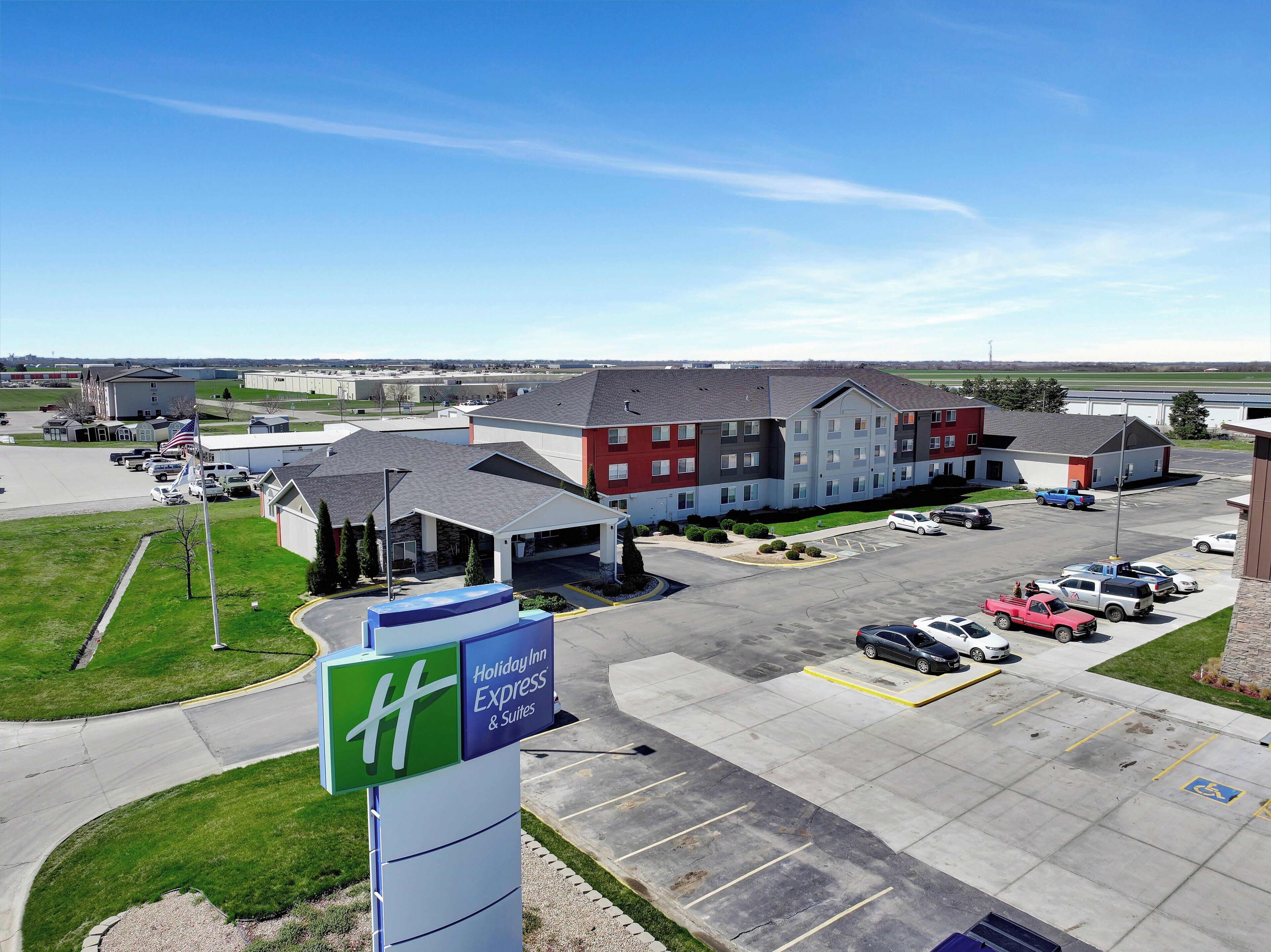 A Holiday Inn Express & Suites with a parking lot, a flag, and a building complex.