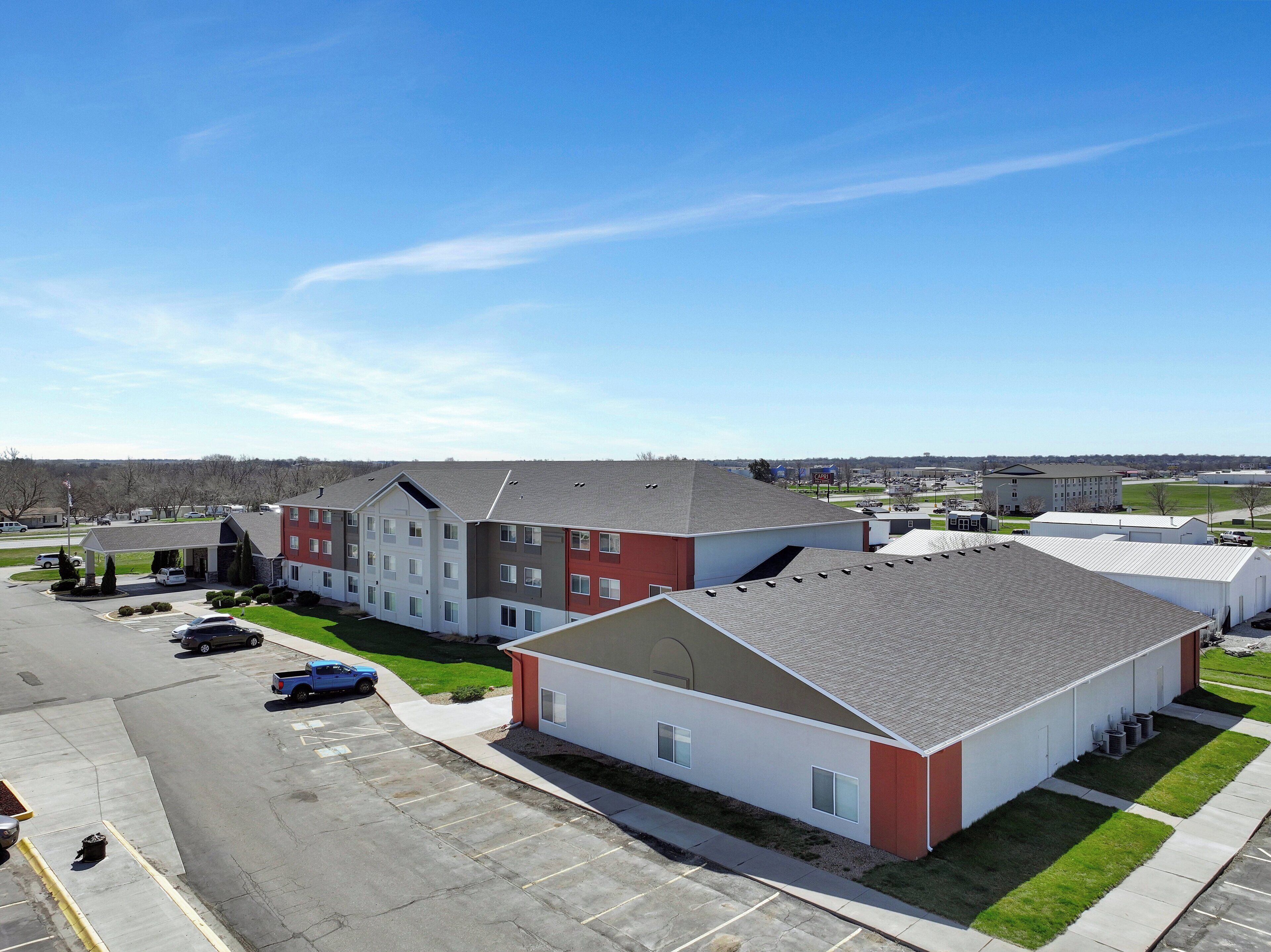 A multi-story building with a parking lot in front.