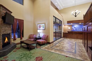 A hotel lobby with a fireplace, seating area, and a reception desk. - Holiday Inn Express Hotel & Suites Cleveland-Streetsboro by IHG (Streetsboro)
