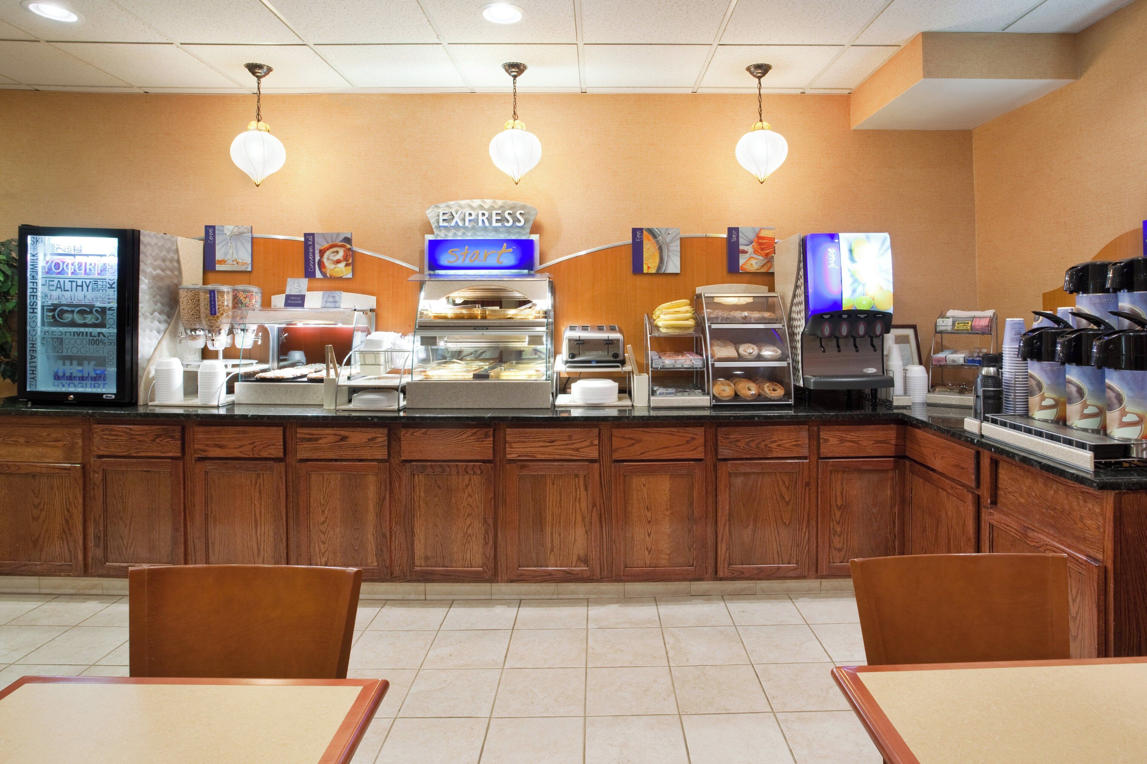 A breakfast bar with a coffee machine, a yogurt dispenser, and a sign that says 'EXPRESS Start'.