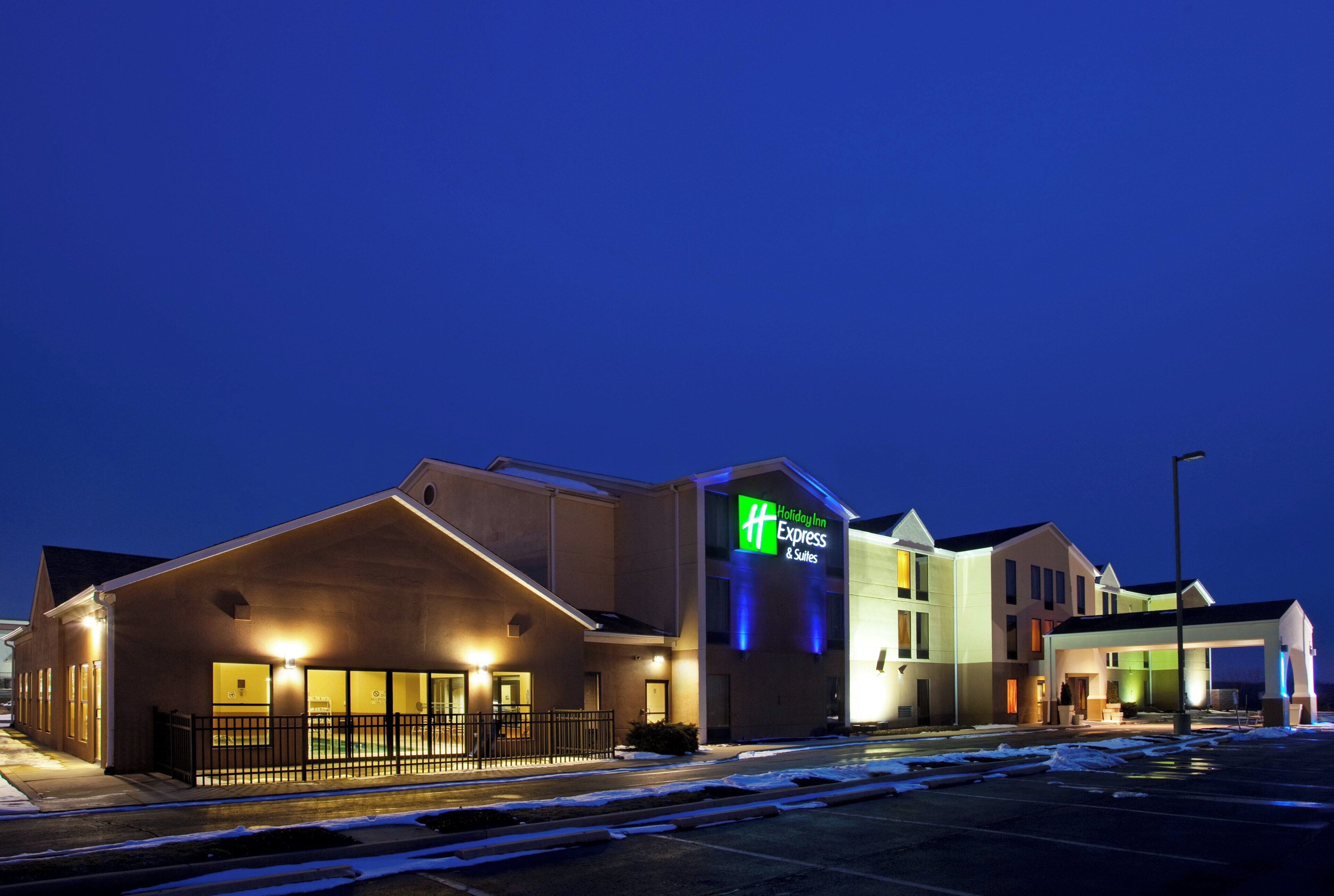 Un hotel Holiday Inn Express & Suites de diseño moderno, con un llamativo letrero verde y blanco.