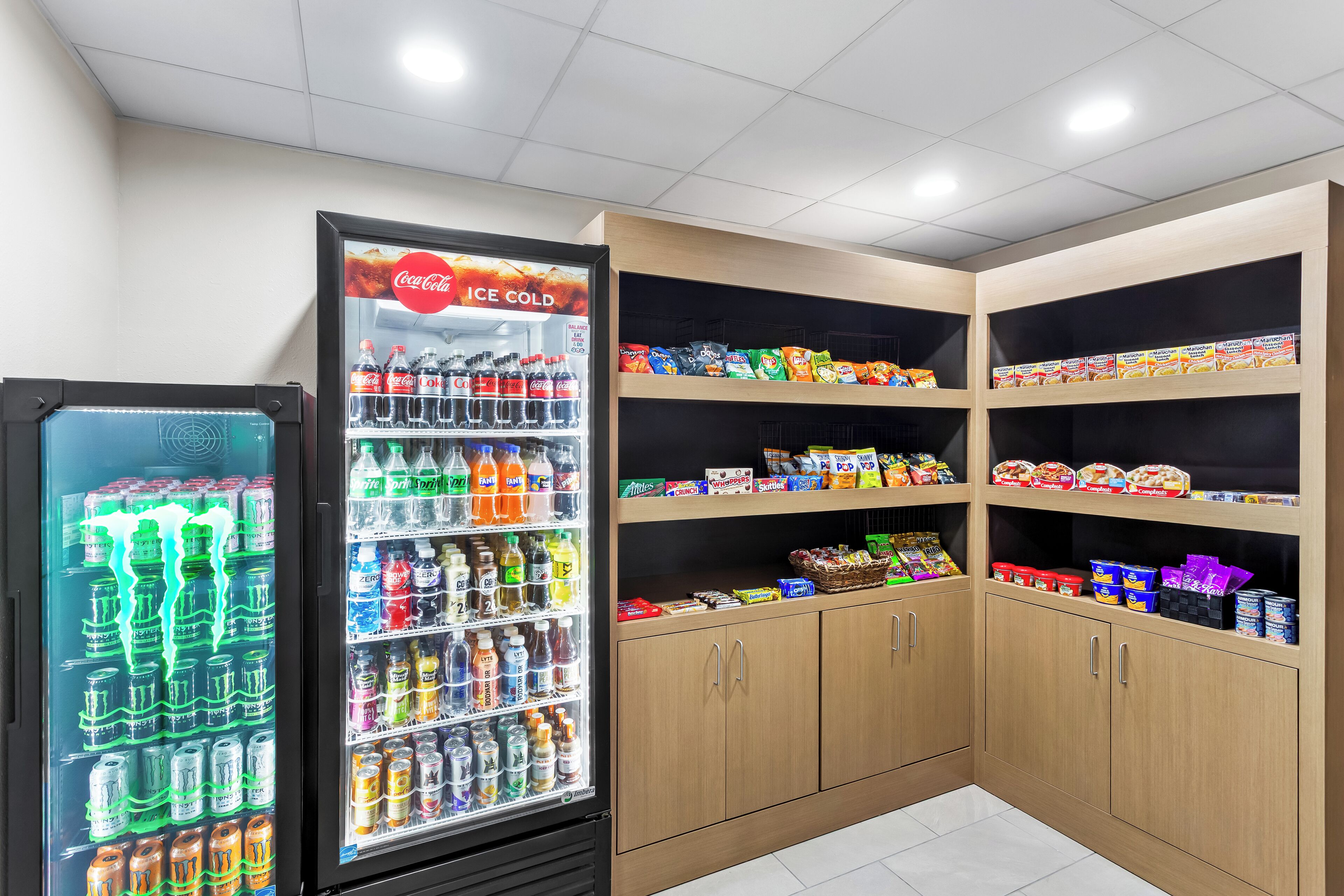 A vending machine with various beverages and a snack shelf stocked with different products.