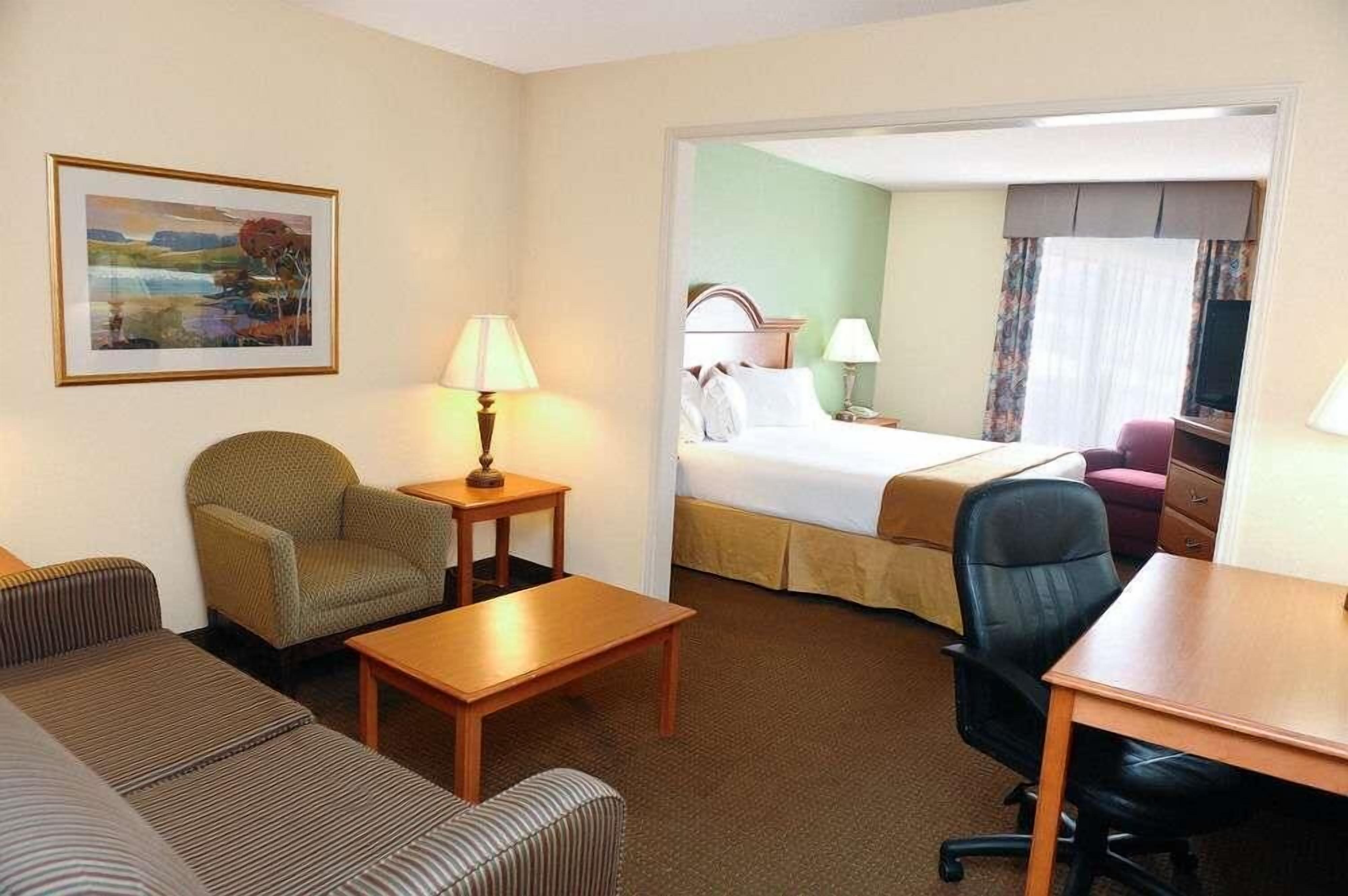 Una habitación de hotel con cama, sofá, escritorio y silla.