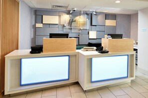 Una recepción con diseño moderno, que cuenta con una superficie plana y un panel iluminado integrado.