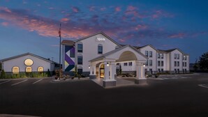 A hotel with a modern design, featuring a central entrance with a covered area and a parking lot in front. - Spark by Hilton North Little Rock (North Little Rock)