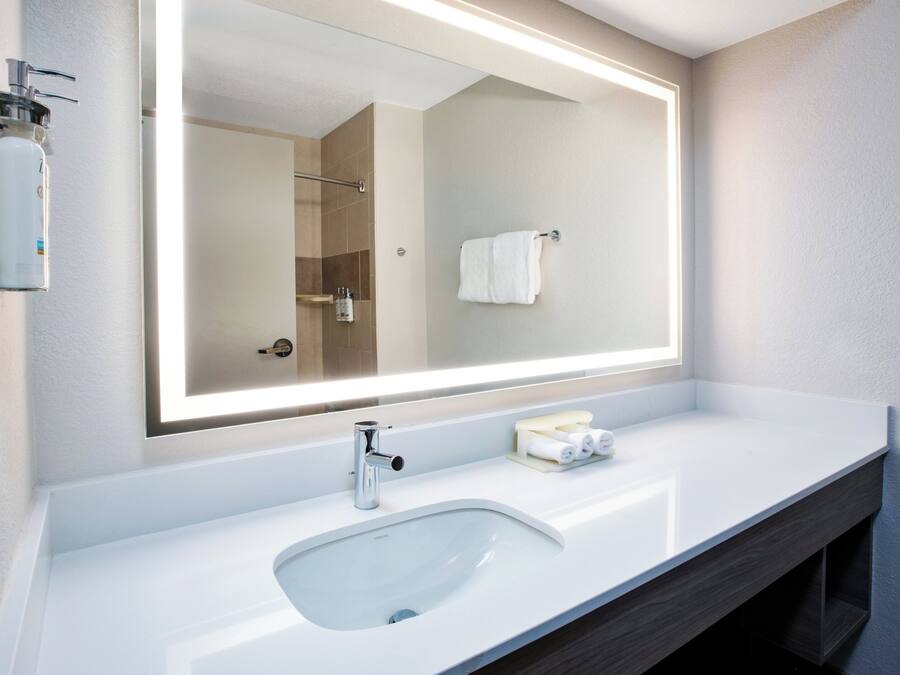 Un bagno moderno con uno specchio grande, un lavandino e un porta asciugamani.