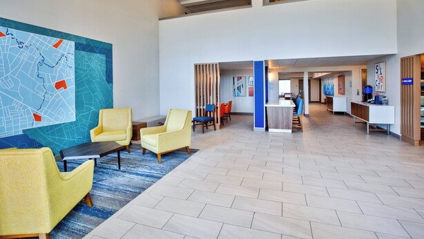 A spacious lobby with modern furniture, a large map on the wall, and a reception desk in the background. - Holiday Inn Express Silver City by IHG (Silver City)