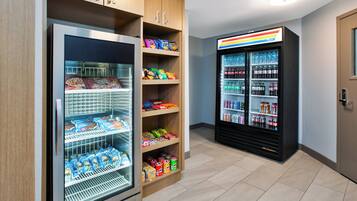A vending machine and a refrigerated display case with snacks and beverages.