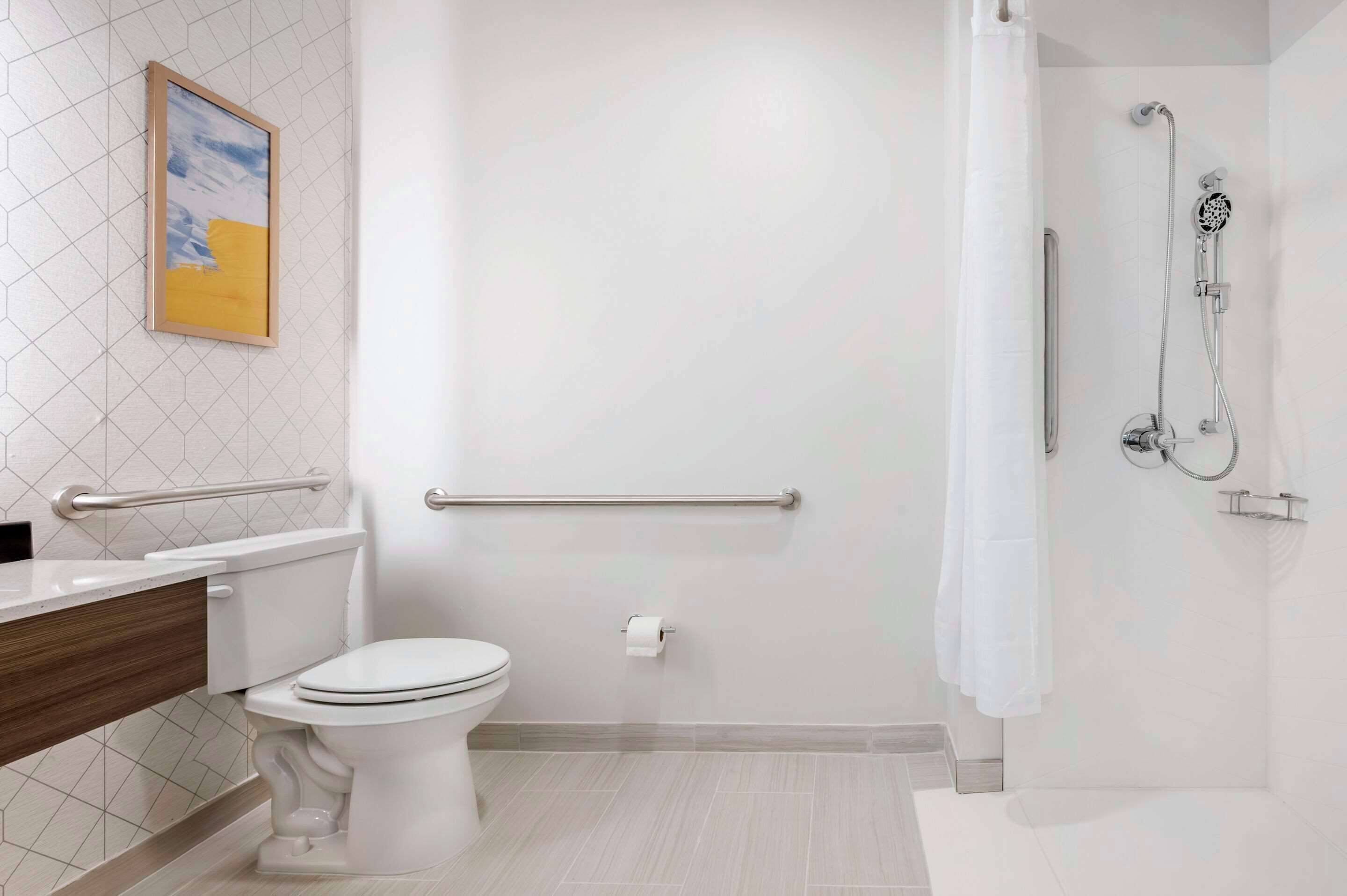 Un baño moderno con inodoro, ducha con cabezal de ducha manual y barandilla.