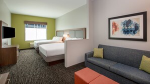 A hotel room with a bed, a sofa, a TV, and a painting on the wall. - Holiday Inn Express Hotel & Suites Columbus by IHG (Columbus)