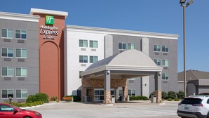 A Holiday Inn Express & Suites building with a stone facade, large windows, and a covered entrance.