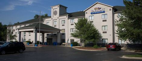A hotel with a central entrance, a clock tower, and a sign for 'BAYMONT BY VYNDAH'.