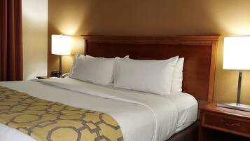 A hotel room with a large bed, two bedside tables with lamps, and a brown headboard.