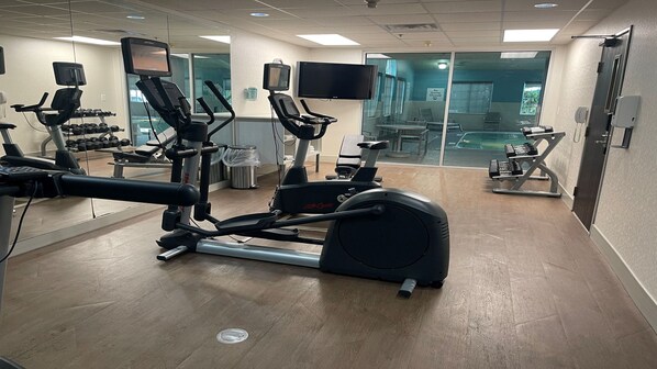 A gym with cardio machines, dumbbells, and a TV screen. - Holiday Inn Express Hotel & Suites Ashtabula-Geneva by IHG (Austinburg)