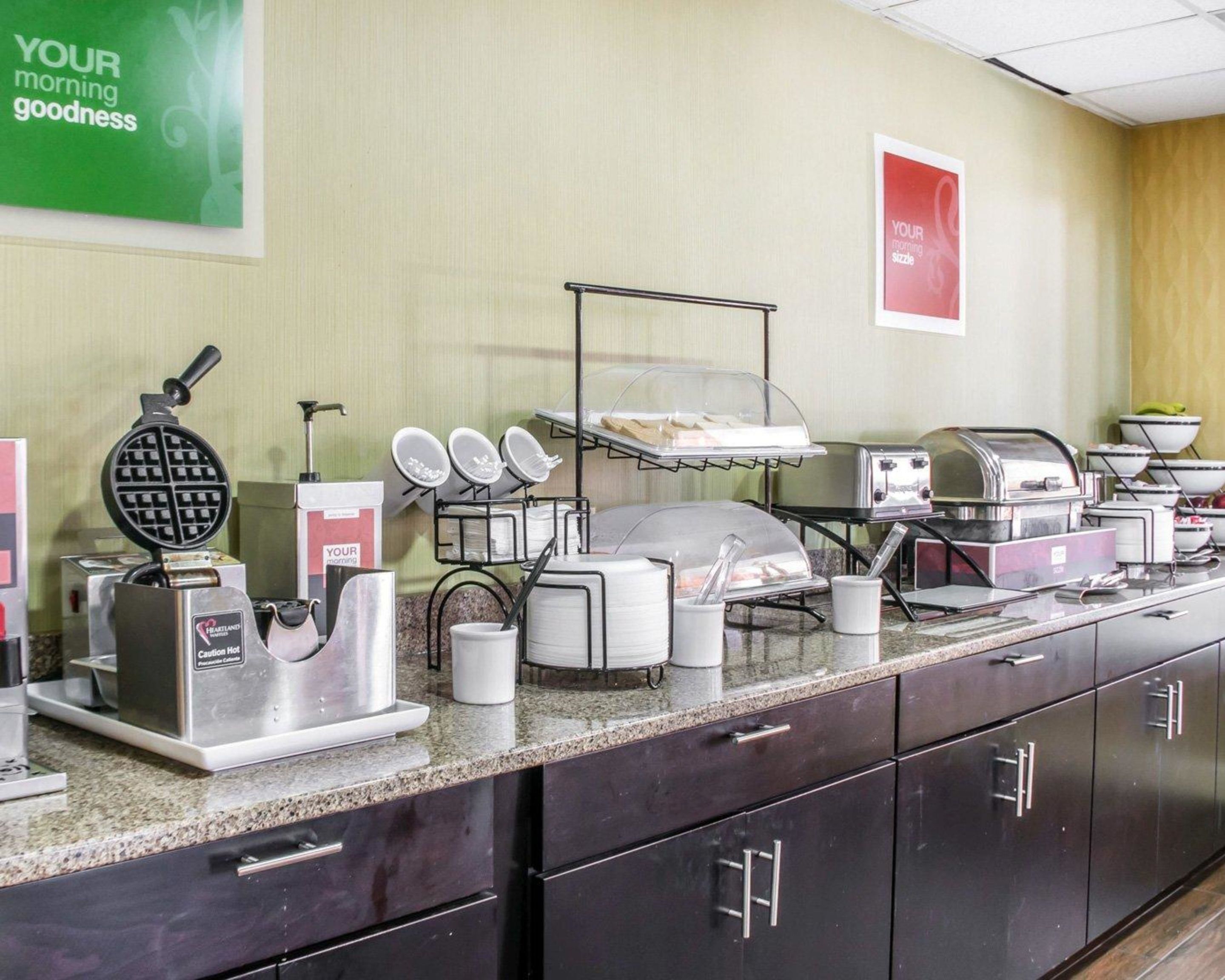 Un'impostazione per colazione a buffet con macchine per waffle, tostapane e angolo caffè.
