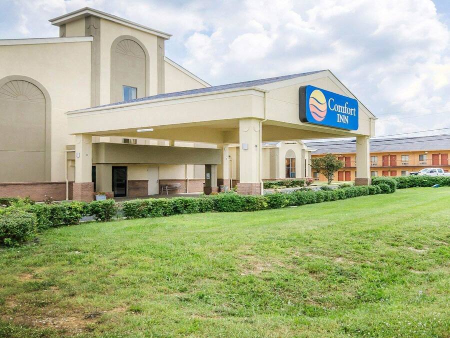 A Comfort Inn hotel with a covered entrance and a grassy lawn in front.