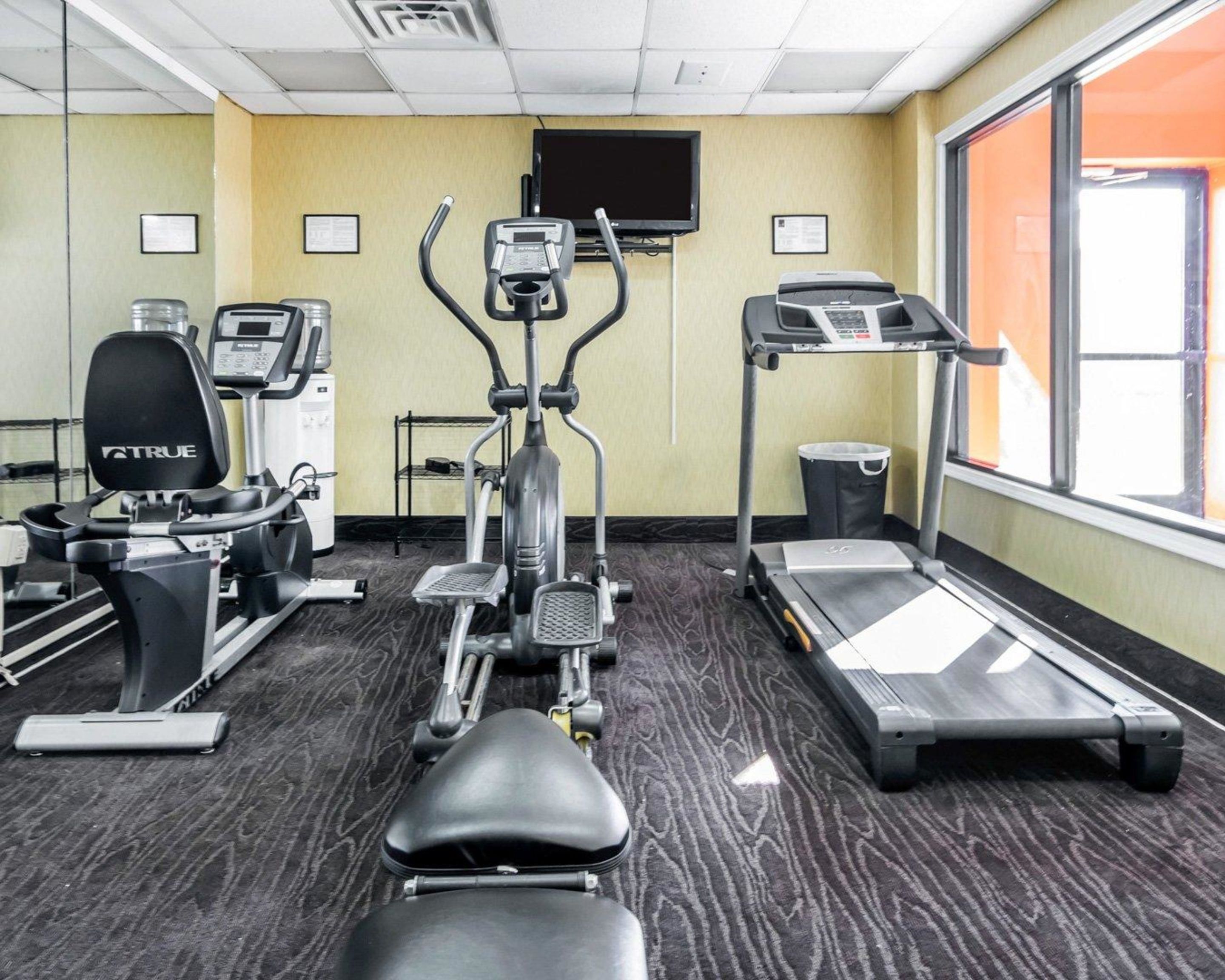 A gym with various exercise equipment including treadmills, an elliptical, and a stationary bike.