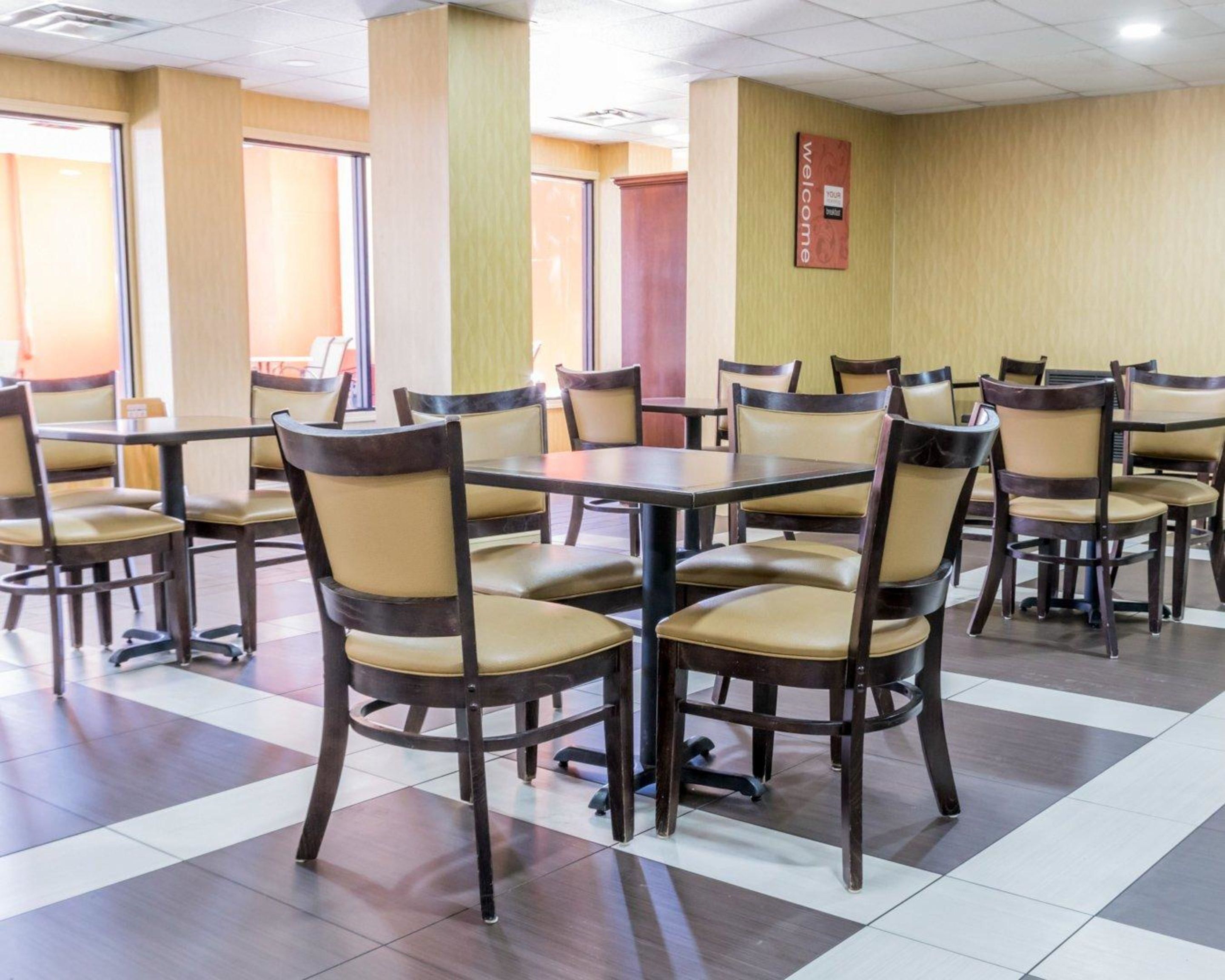 A conference room with multiple tables and chairs, large windows, and a 'Welcome' sign on the wall.