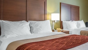 A hotel room with a large bed, a bedside table with a lamp, and a telephone. - Comfort Inn Winchester (Winchester)