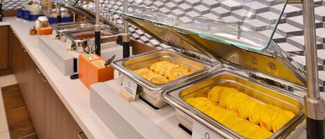 Un buffet proposant différents types d’omelettes et d’omelettes au fromage, présentés dans des plateaux clairement identifiés.
