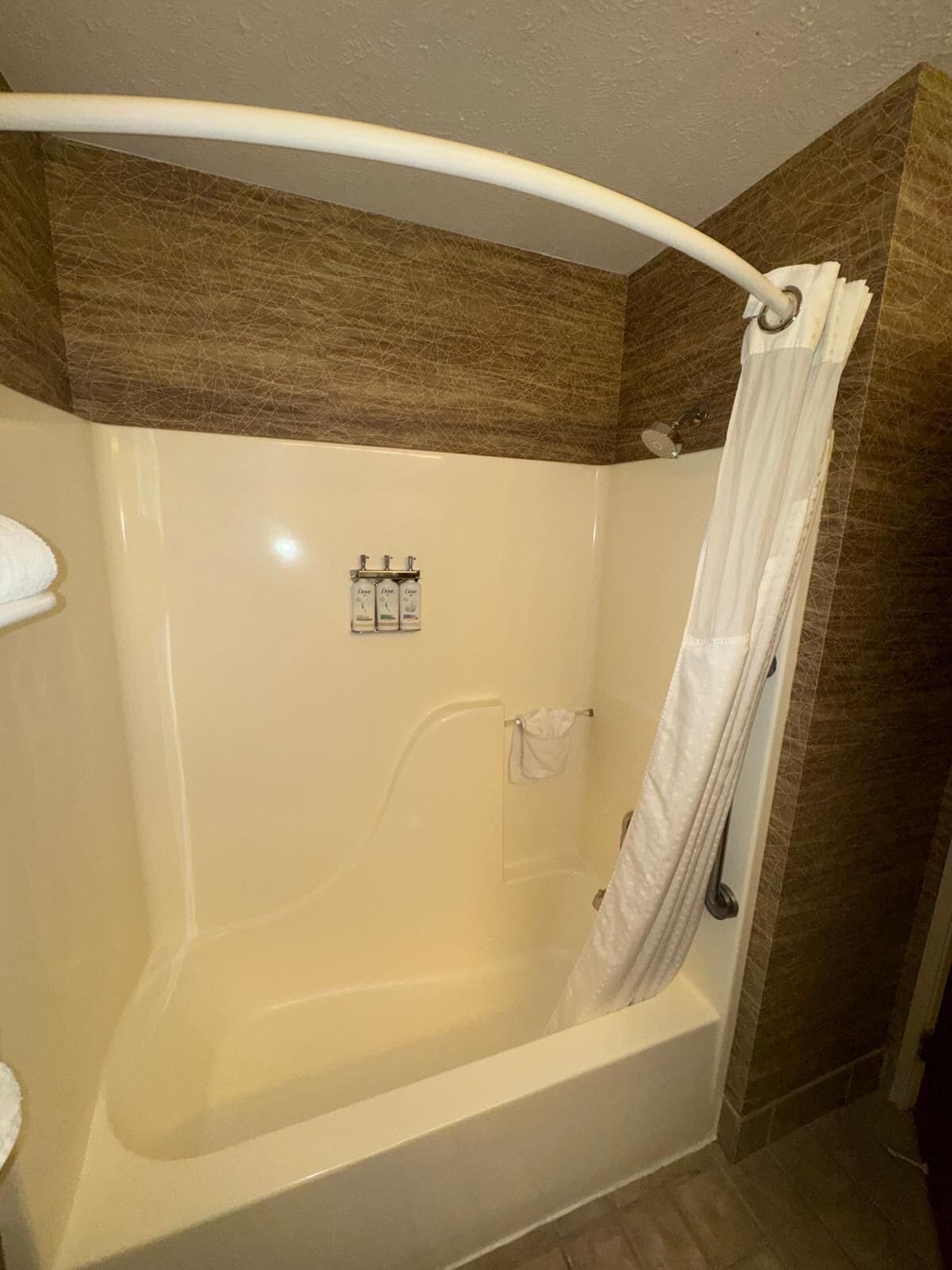 A bathroom with a bathtub, a shower curtain, and a towel rack.