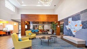 Un hall d’entrée spacieux, doté de meubles modernes, d’un coin salon et d’une grande carte murale.