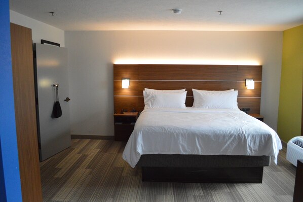 Ein Hotelzimmer mit einem großen Bett, einem Holz-Kopfteil, Nachttischen und einem Wandheizkörper.