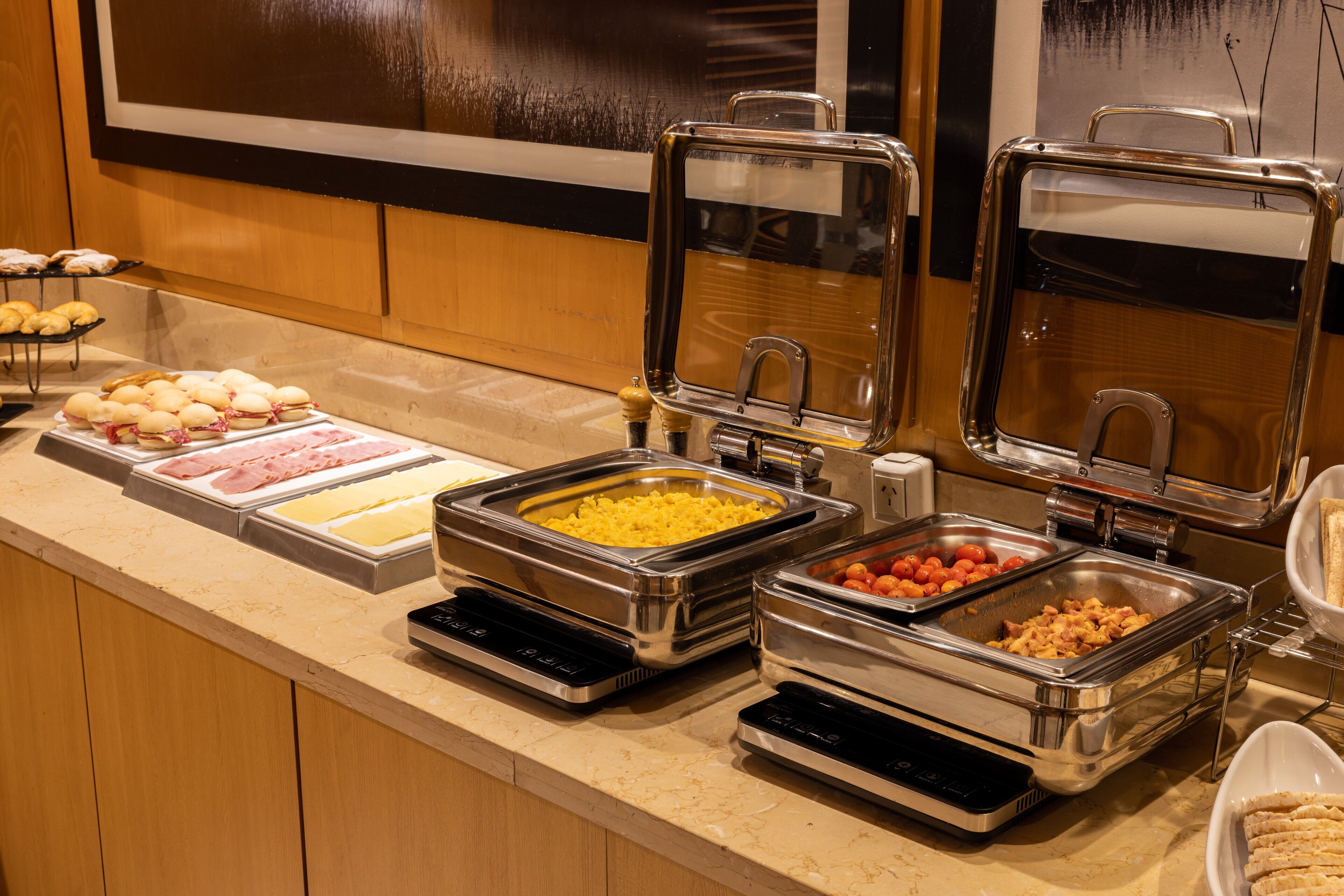 A buffet with various food options including meats, cheeses, and vegetables.