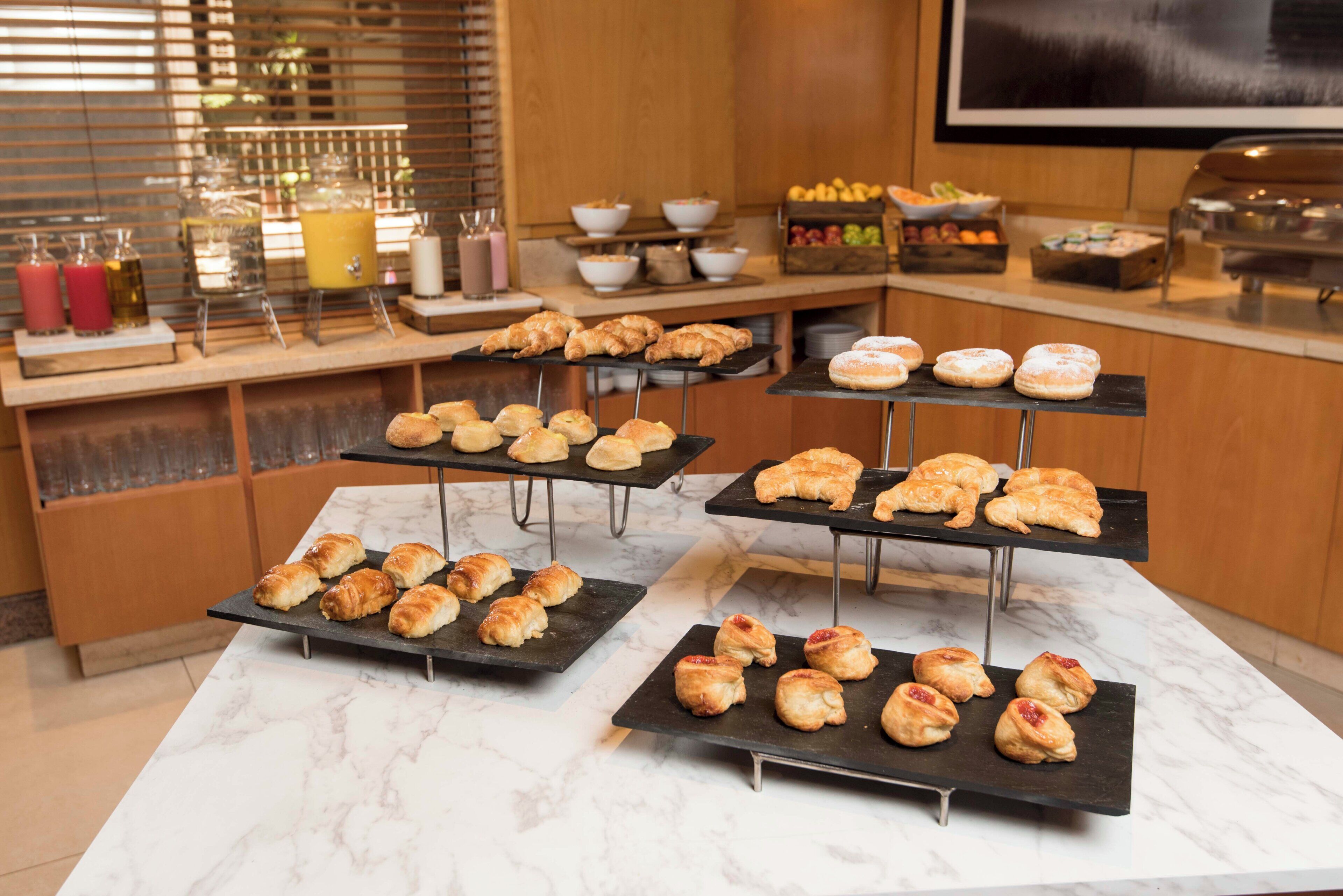 A buffet setup with various pastries and beverages.
