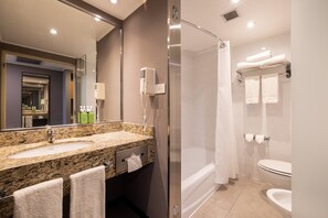 A modern bathroom with a granite sink, a glass shower enclosure, and a white toilet. - Holiday Inn Express Puerto Madero by IHG (Buenos Aires)