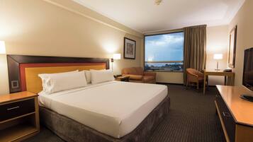 Een hotelkamer met een groot bed, een bureau, een stoel en een televisietoestel.