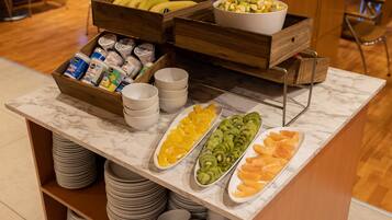 A buffet with various fruits and beverages.