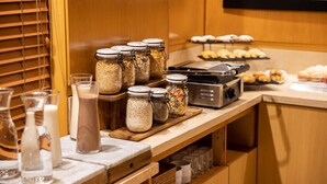 A breakfast buffet with jars of cereal, milk, and a coffee machine. - Holiday Inn Express Puerto Madero by IHG (Buenos Aires)