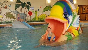 Une piscine avec un grand toboggan coloré en forme de poisson.