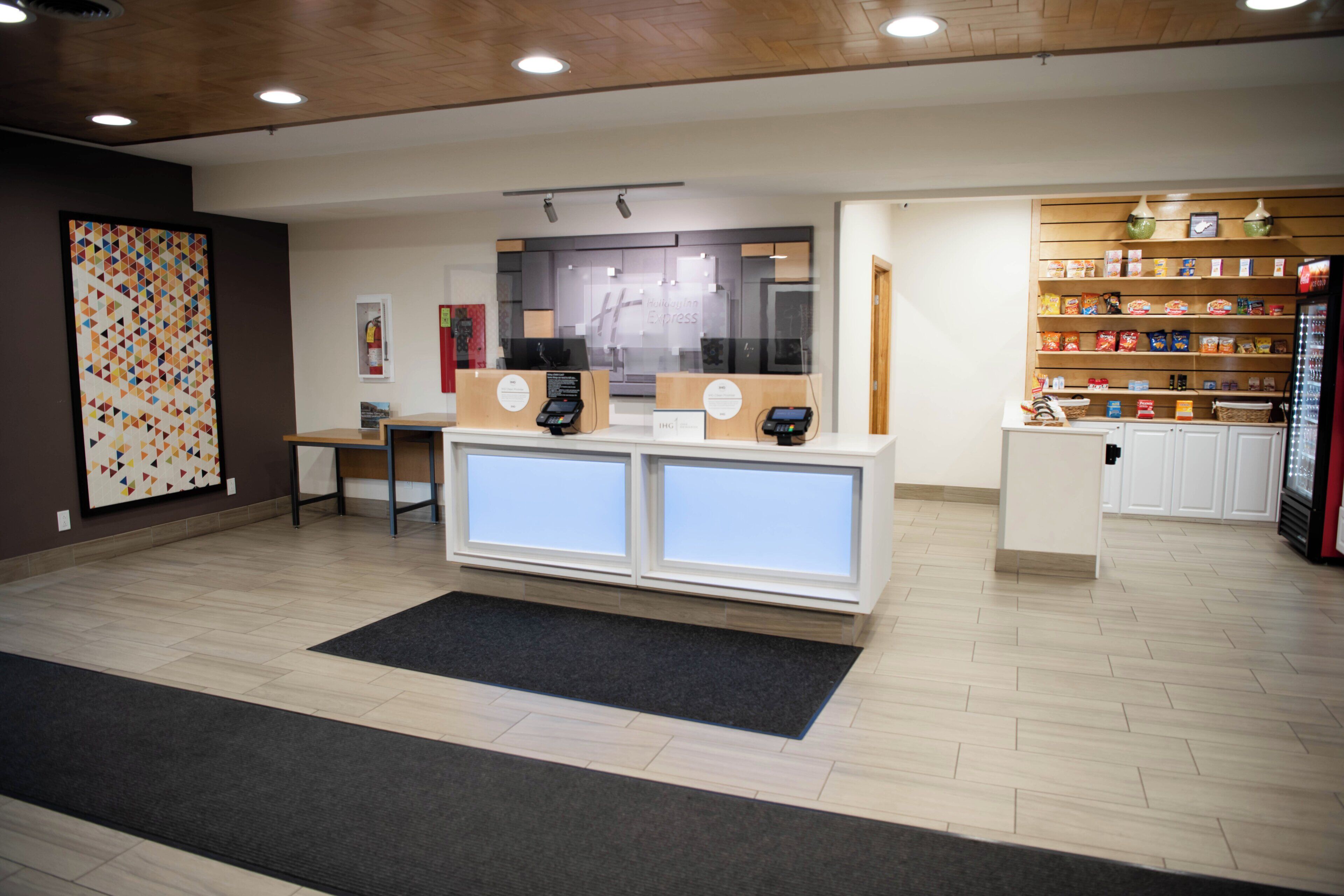 A reception area with a counter, a digital kiosk, and a display of snacks.