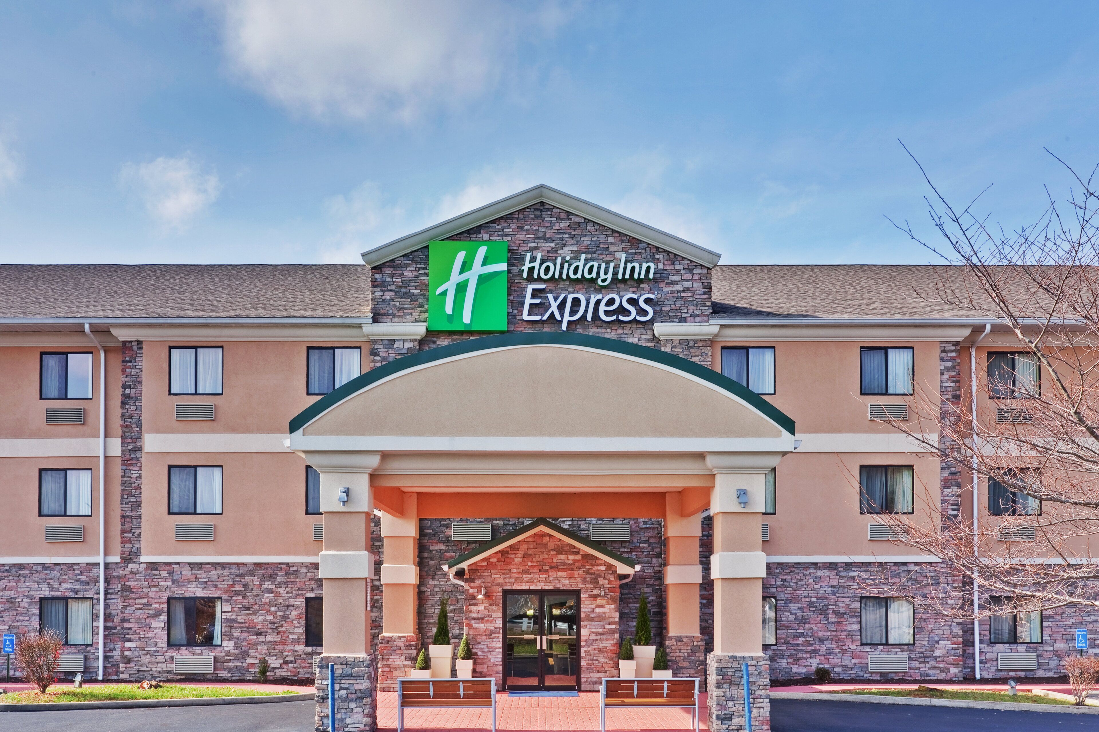 A Holiday Inn Express building with a brick facade, large windows, and a prominent entrance.