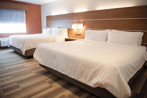 A hotel room with two beds, a wooden headboard, a nightstand with a lamp, and a window with blinds. - Holiday Inn Express Winfield by IHG (Hurricane)