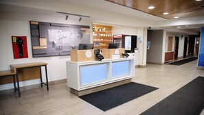 A reception area with a wooden desk, a computer, and a refrigerator. - Holiday Inn Express Winfield by IHG (Hurricane)