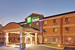 Edificio de Holiday Inn Express con fachada de ladrillo, múltiples ventanas y un área de entrada cubierta.