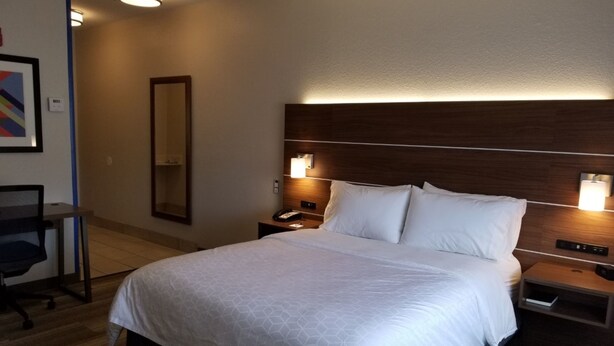 A hotel room with a large bed, bedside tables, a desk, and a chair. - Holiday Inn Express Winfield by IHG (Hurricane)